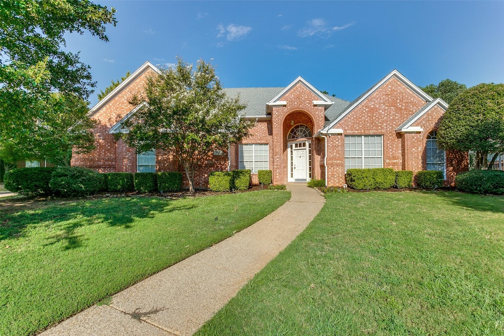 view of front of house featuring a front yard and brick siding