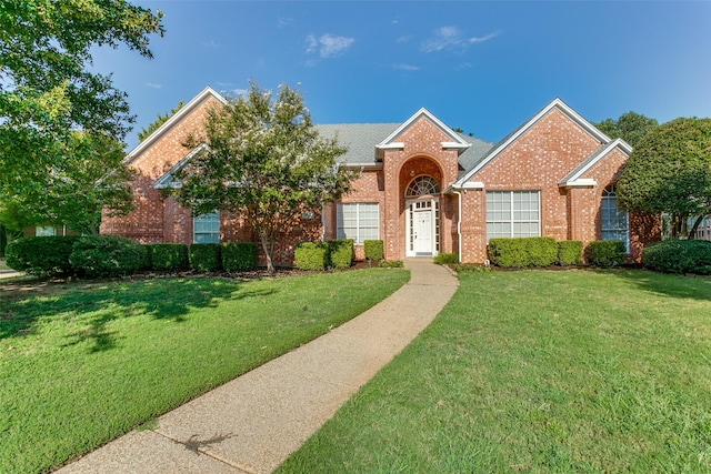 view of front of house featuring a front yard and brick siding