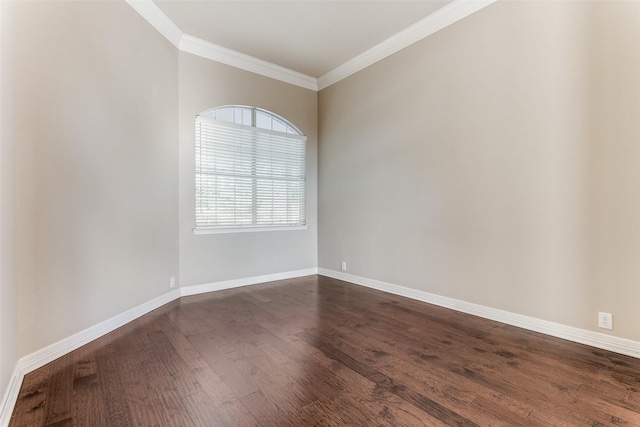 empty room with dark wood-style floors, ornamental molding, and baseboards