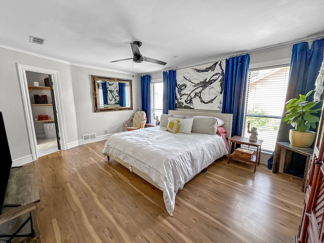 bedroom with ceiling fan, crown molding, and wood-type flooring