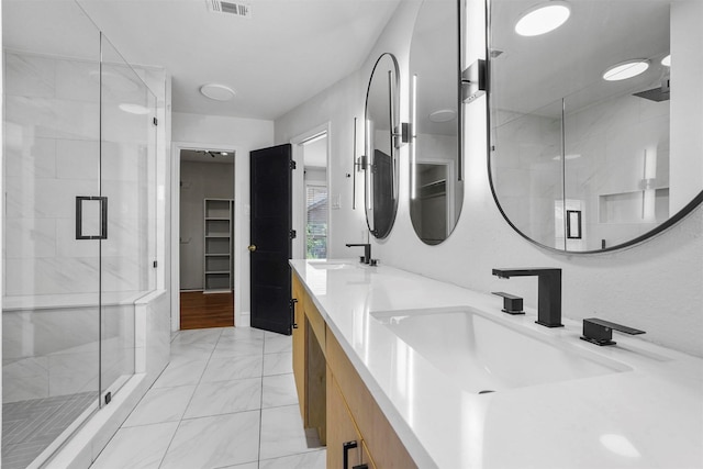 bathroom with a shower with door and vanity