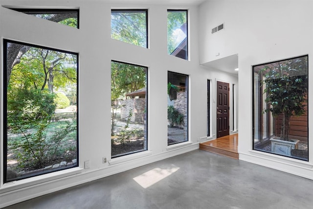 spare room with concrete floors and a towering ceiling