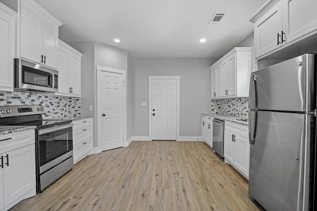 kitchen with appliances with stainless steel finishes, white cabinets, and light stone countertops