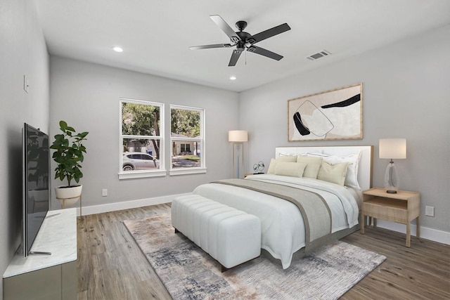 bedroom featuring visible vents, baseboards, wood finished floors, and recessed lighting