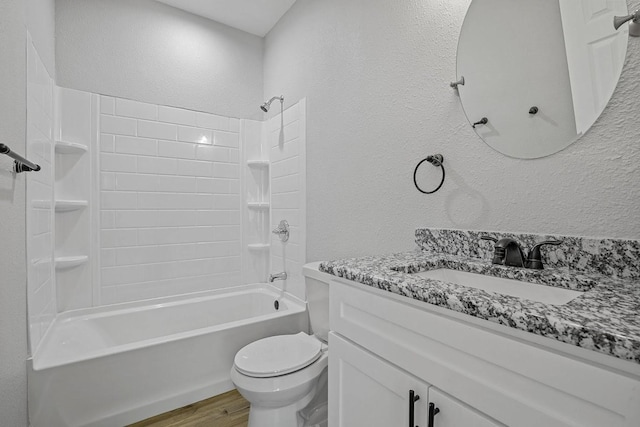 full bathroom with a textured wall, toilet, wood finished floors, vanity, and bathing tub / shower combination