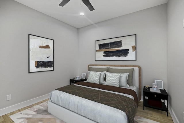 bedroom with a ceiling fan, light wood-style flooring, and baseboards