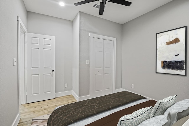 bedroom featuring ceiling fan, light wood-type flooring, and a closet