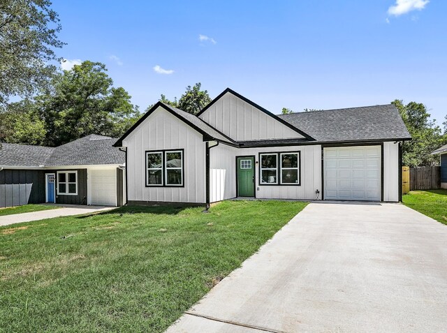 modern farmhouse featuring a garage and a front lawn