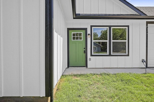 doorway to property featuring a lawn