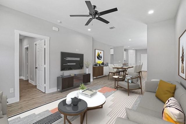 living area featuring recessed lighting, visible vents, light wood-style floors, ceiling fan, and baseboards