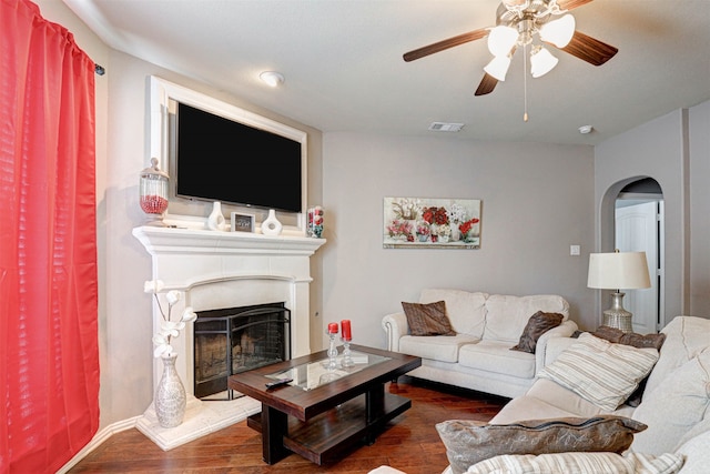 living room with ceiling fan and dark wood-type flooring