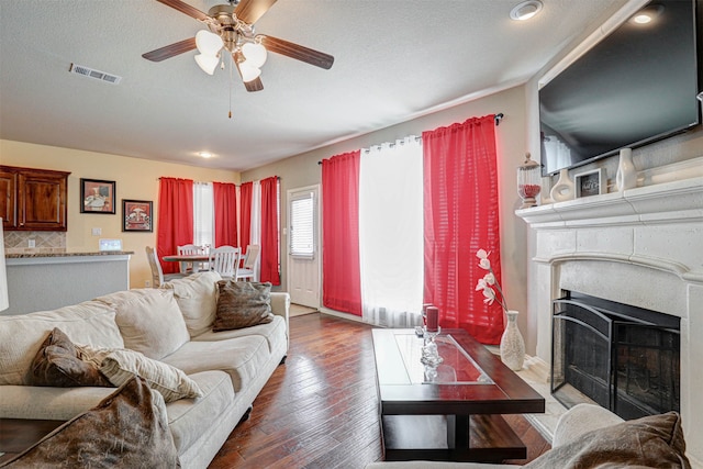 living room featuring a textured ceiling, ceiling fan, and wood-type flooring