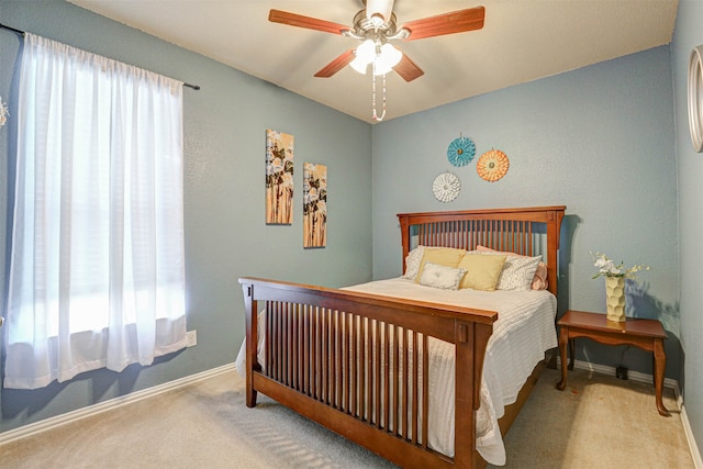 carpeted bedroom featuring ceiling fan and multiple windows