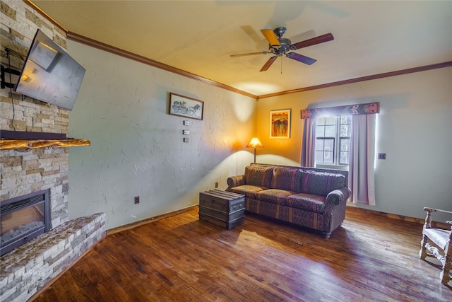 living room with a stone fireplace, ceiling fan, hardwood / wood-style floors, and ornamental molding