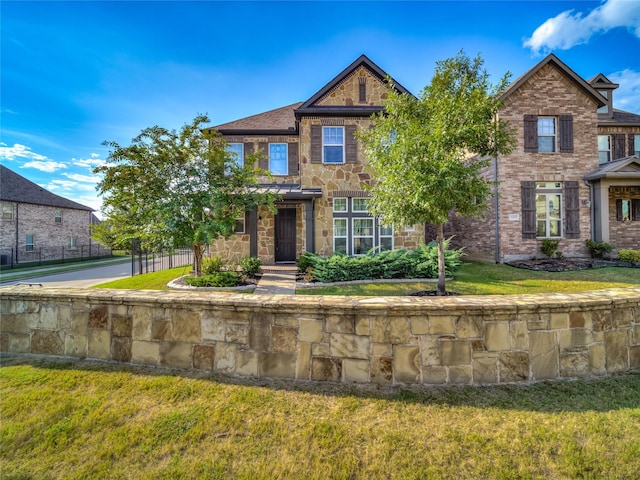 view of front facade featuring stone siding, fence, and a front lawn