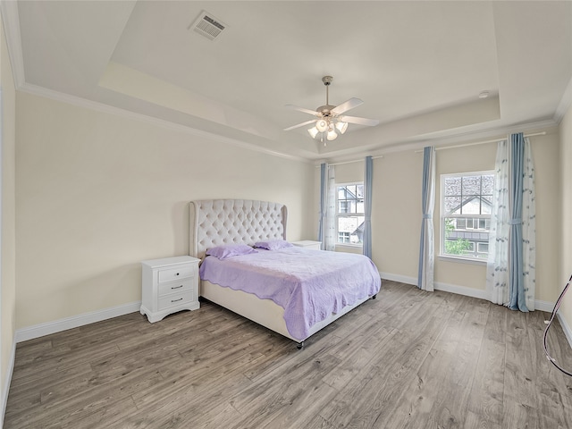 bedroom featuring ceiling fan, a raised ceiling, and hardwood / wood-style floors