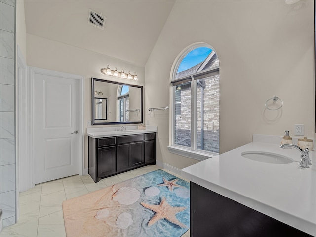 bathroom with tile patterned flooring, lofted ceiling, and vanity