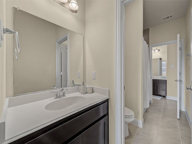 bathroom with tile patterned flooring, toilet, walk in shower, and vanity