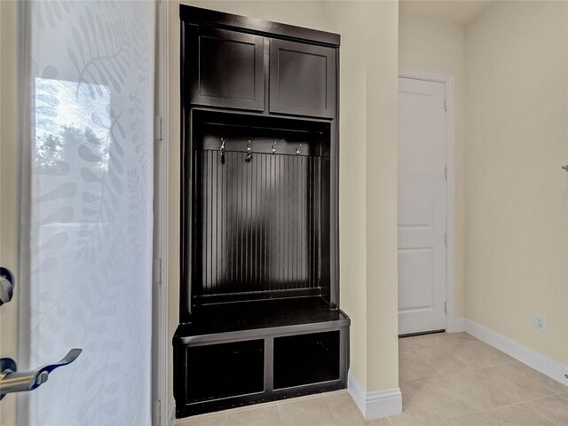 mudroom featuring light tile patterned flooring and baseboards