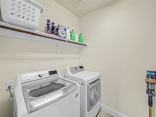 washroom with light tile patterned floors and washing machine and clothes dryer