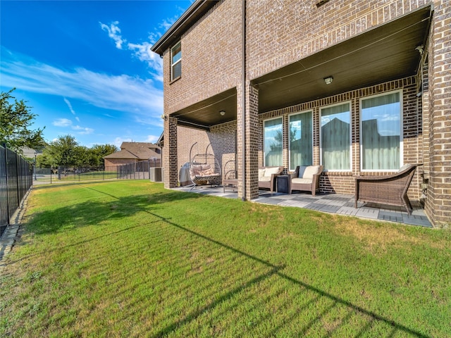 exterior space with a lawn, a patio, a fenced backyard, an outdoor hangout area, and brick siding