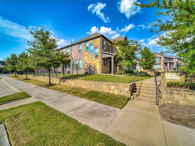 exterior space with a residential view, a yard, and fence