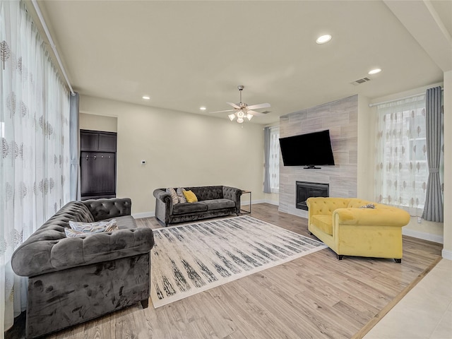 living area featuring recessed lighting, a fireplace, and light wood-style flooring