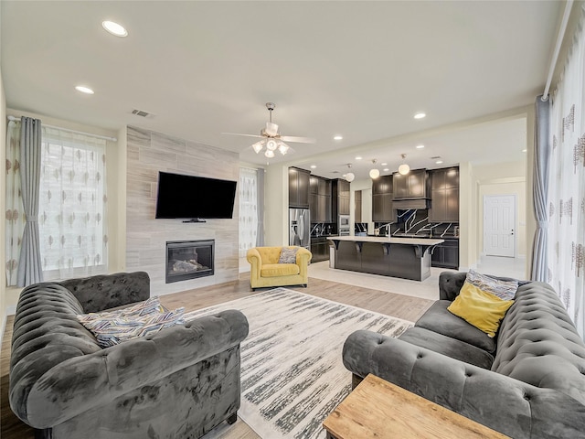 living room featuring a fireplace, recessed lighting, visible vents, light wood-style floors, and ceiling fan