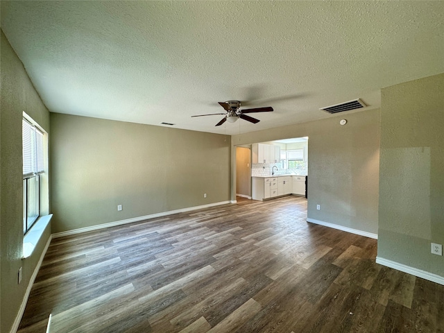 interior space featuring a textured ceiling, ceiling fan, hardwood / wood-style floors, and sink