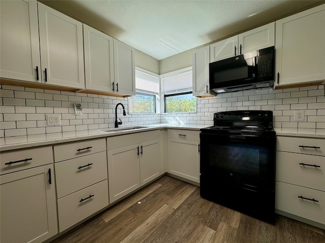 kitchen featuring white cabinetry, tasteful backsplash, sink, black appliances, and dark hardwood / wood-style flooring