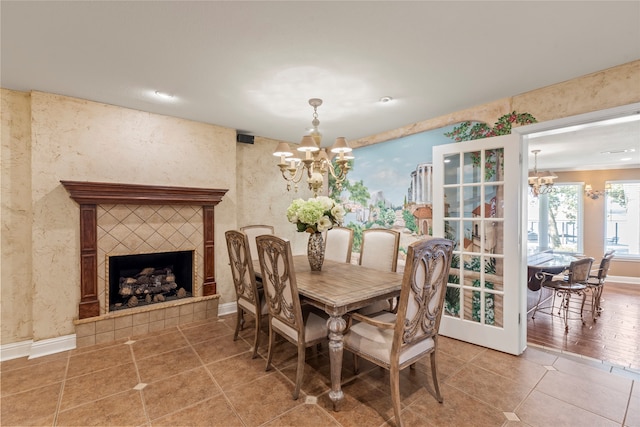 dining space with a fireplace, an inviting chandelier, and hardwood / wood-style flooring