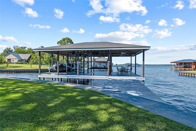 dock area with a lawn and a water view