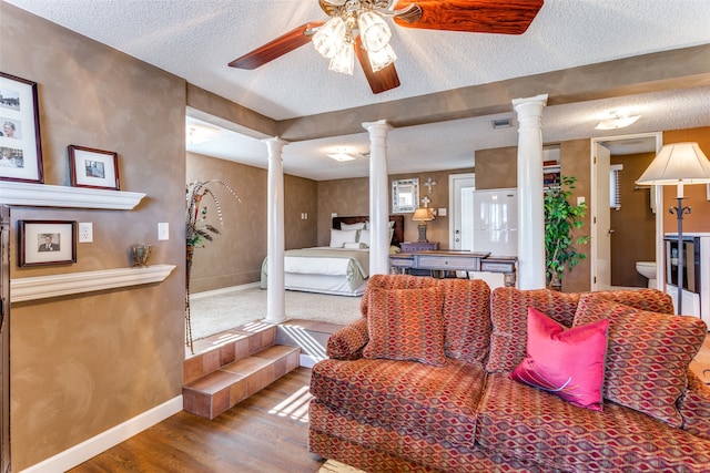 living room with ornate columns, ceiling fan, a textured ceiling, and wood-type flooring