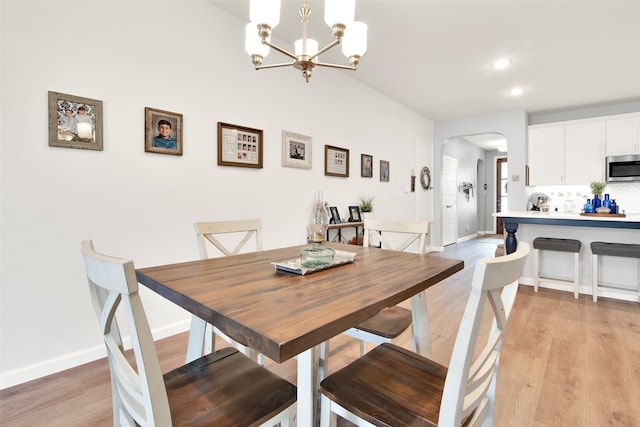 dining space with light hardwood / wood-style flooring and a chandelier