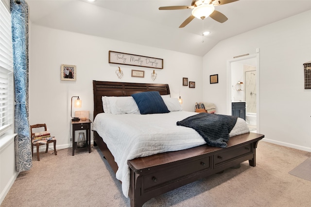 bedroom with ceiling fan, light colored carpet, ensuite bathroom, and lofted ceiling