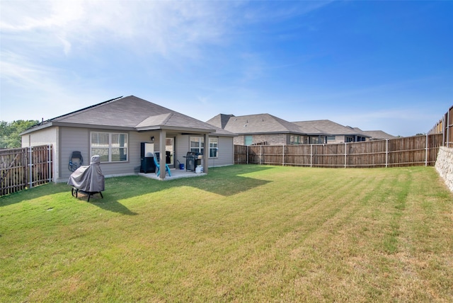 rear view of property featuring a patio area and a yard