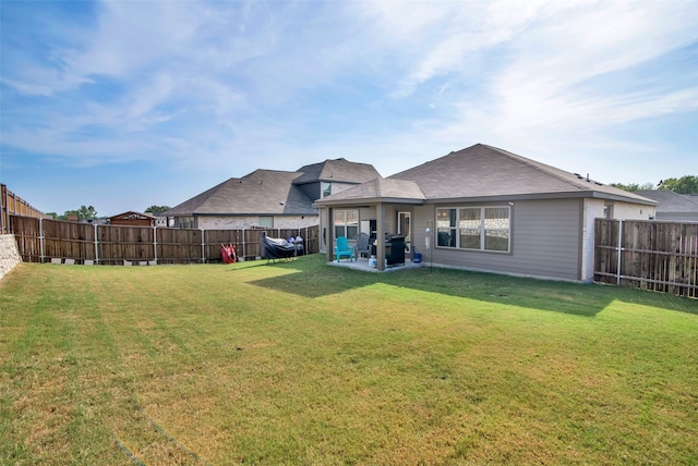 rear view of property featuring a patio area and a lawn