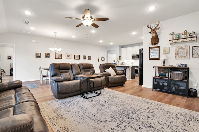 living room with light wood-type flooring, ceiling fan with notable chandelier, and sink