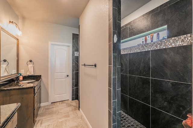 bathroom featuring a tile shower and vanity