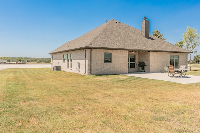 back of house with a patio, central air condition unit, and a lawn