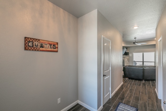 hall featuring a textured ceiling and dark hardwood / wood-style floors