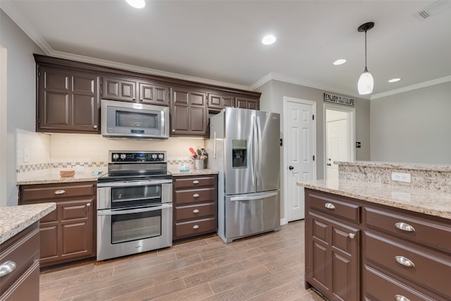 kitchen with backsplash, appliances with stainless steel finishes, and ornamental molding