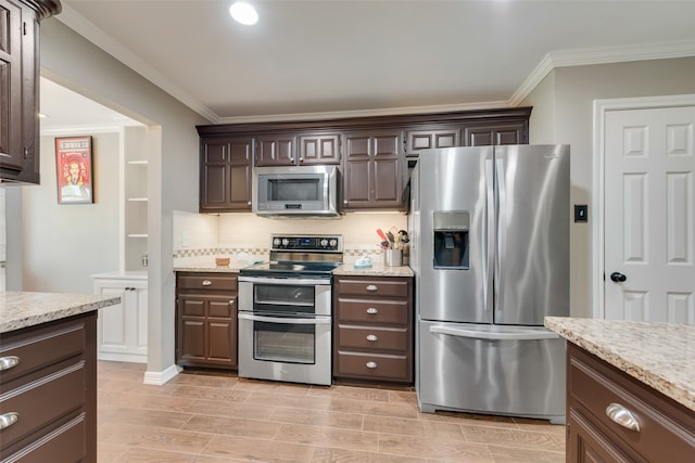 kitchen with decorative backsplash, appliances with stainless steel finishes, light stone counters, and dark brown cabinets