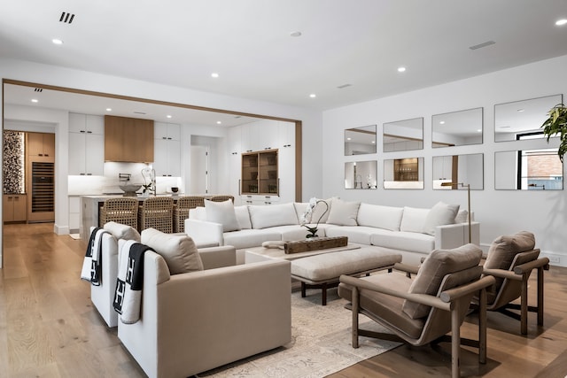 living room featuring sink and light hardwood / wood-style flooring