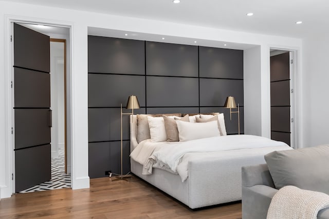 bedroom featuring hardwood / wood-style flooring and refrigerator