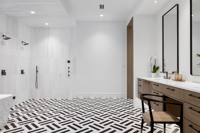 bathroom with tiled shower and vanity