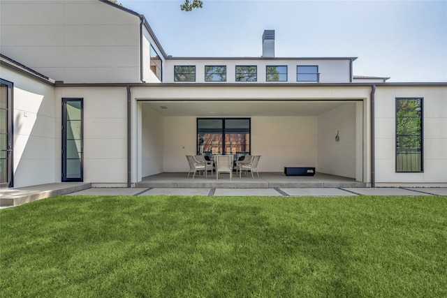 rear view of property featuring a lawn and a patio