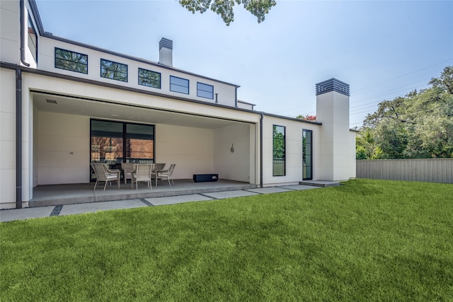 back of house featuring a patio area and a yard