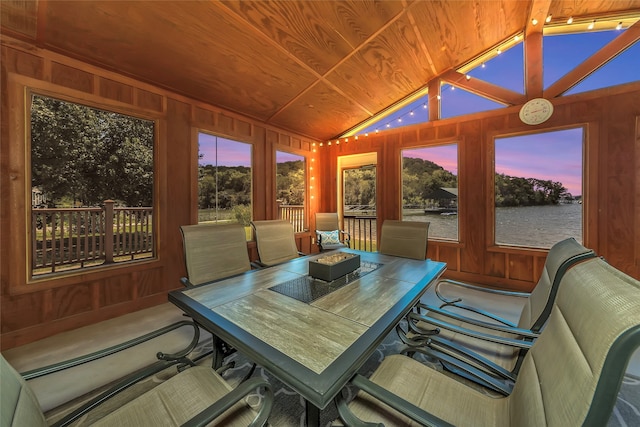 sunroom featuring plenty of natural light, a water view, and lofted ceiling