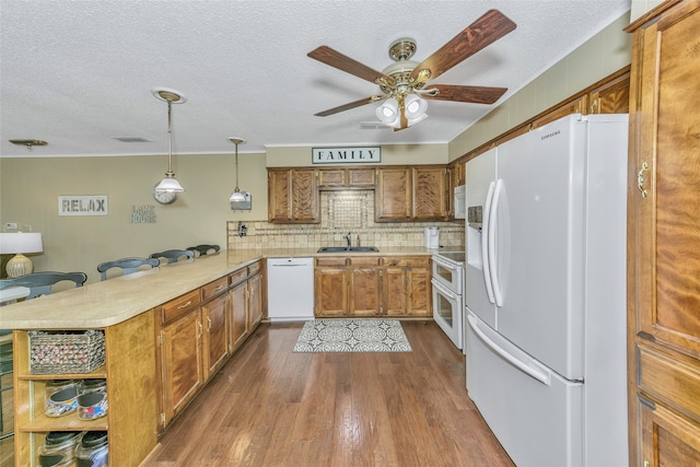 kitchen featuring ceiling fan, dark wood-type flooring, tasteful backsplash, hanging light fixtures, and white appliances